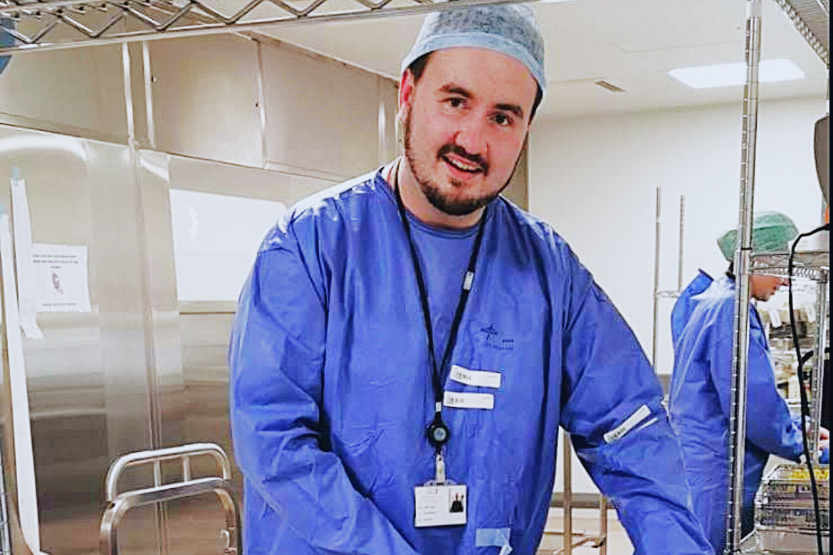 Jamie Dunne in blue scrubs in a hospital setting